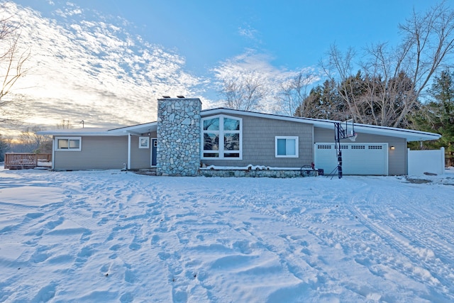 snow covered property with a garage