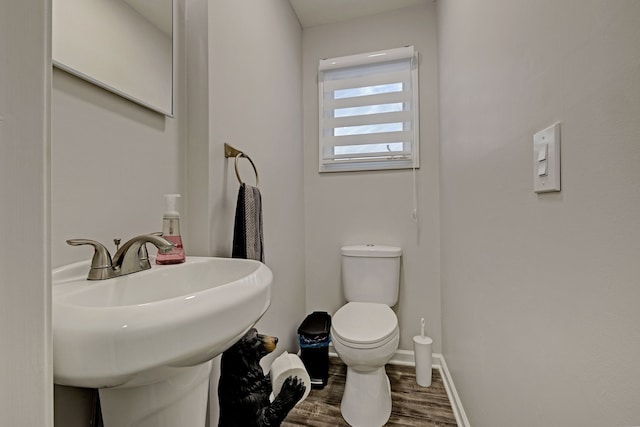 bathroom with toilet, wood-type flooring, and sink