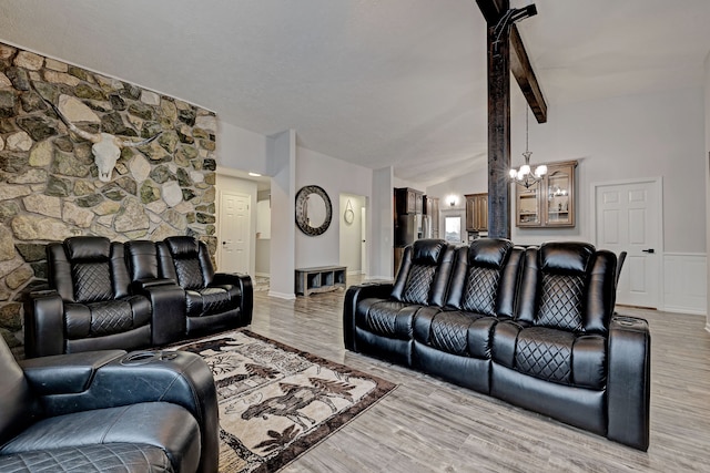 living room featuring light hardwood / wood-style floors, lofted ceiling, and a chandelier