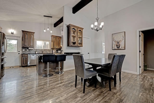 dining room with a chandelier, beam ceiling, hardwood / wood-style floors, and high vaulted ceiling