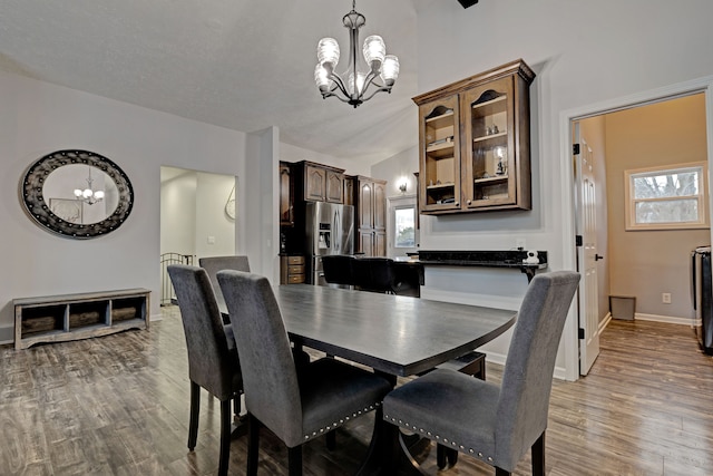 dining space featuring hardwood / wood-style floors and a chandelier