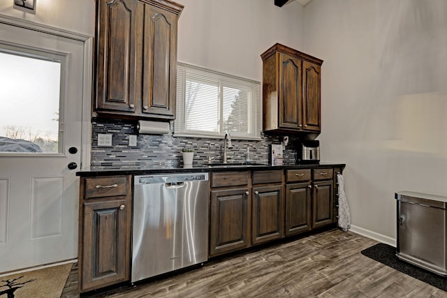 kitchen with backsplash, dark wood-type flooring, dark brown cabinets, dishwasher, and sink