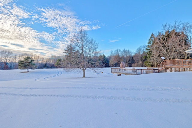 yard layered in snow featuring a wooden deck