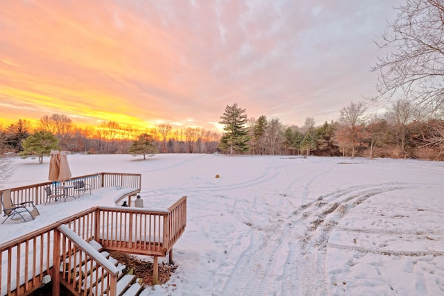 yard layered in snow featuring a deck