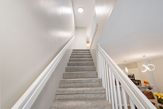 stairs with an inviting chandelier