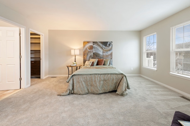 carpeted bedroom with a closet and a walk in closet