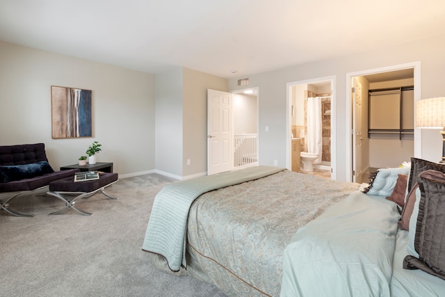 bedroom featuring light colored carpet, a closet, a spacious closet, and connected bathroom