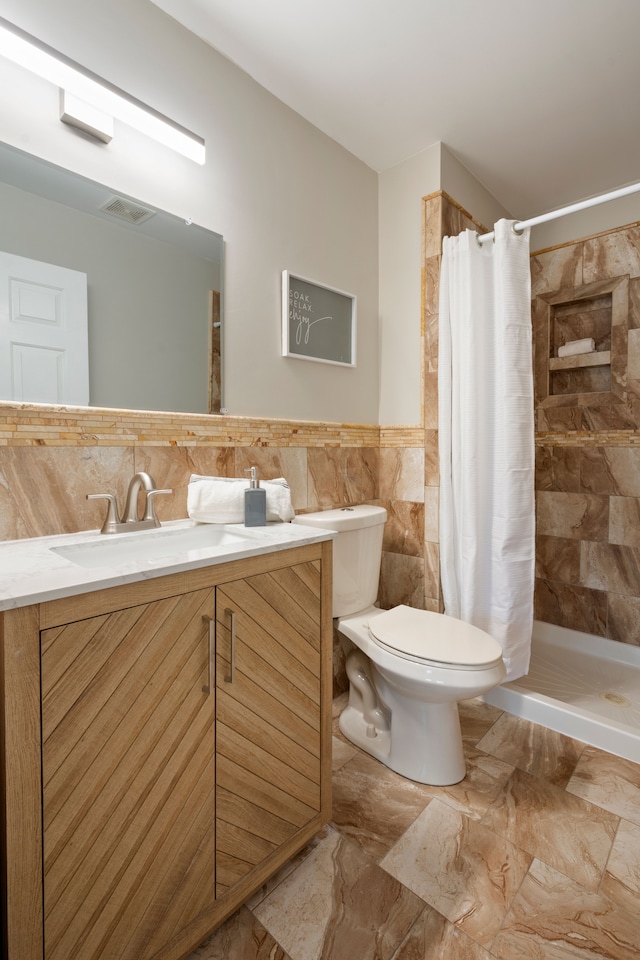 bathroom featuring curtained shower, tile walls, toilet, and vanity