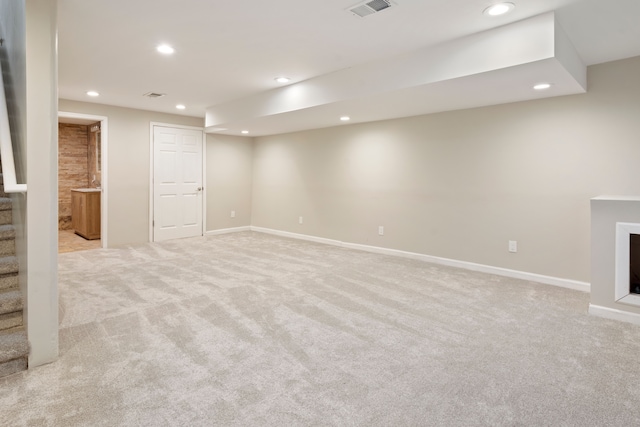 basement featuring light carpet