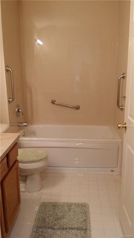 bathroom with toilet, vanity, and tile patterned flooring