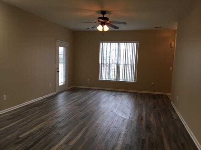 empty room with dark wood-type flooring and ceiling fan