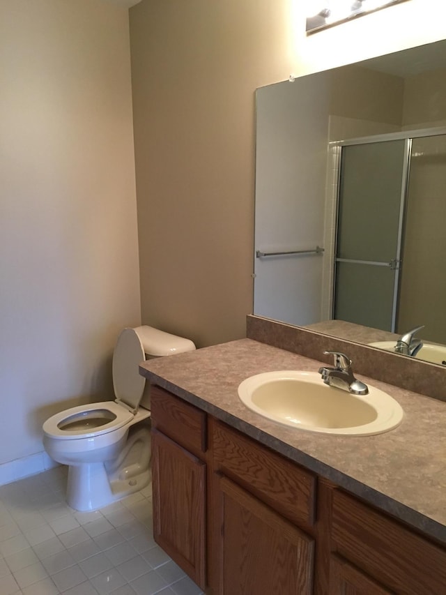 bathroom with walk in shower, vanity, tile patterned floors, and toilet