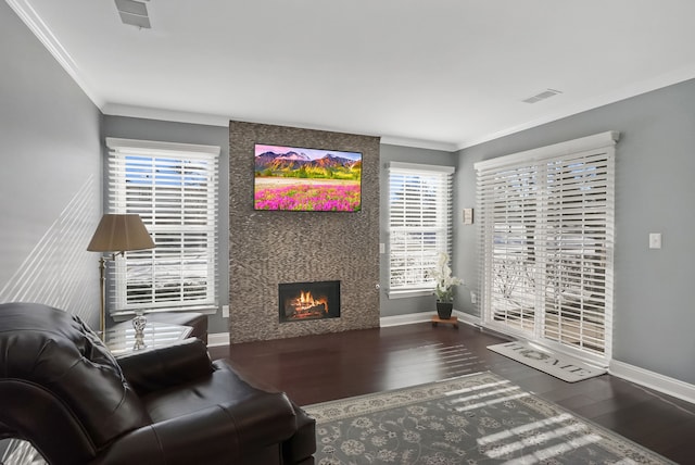 living room featuring crown molding, a fireplace, and hardwood / wood-style flooring