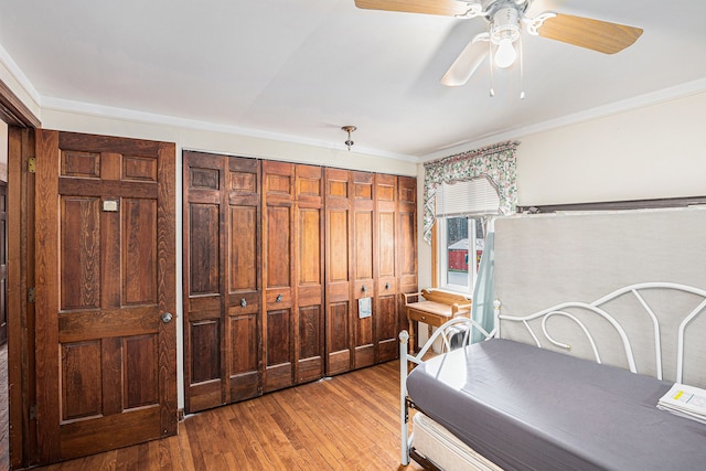 bedroom featuring ceiling fan, crown molding, and light hardwood / wood-style floors