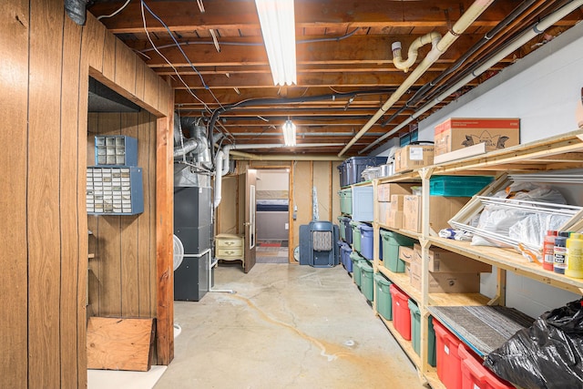 basement with heating unit and wooden walls