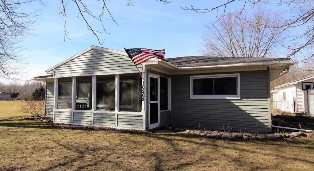 view of front of home featuring a front lawn and a sunroom