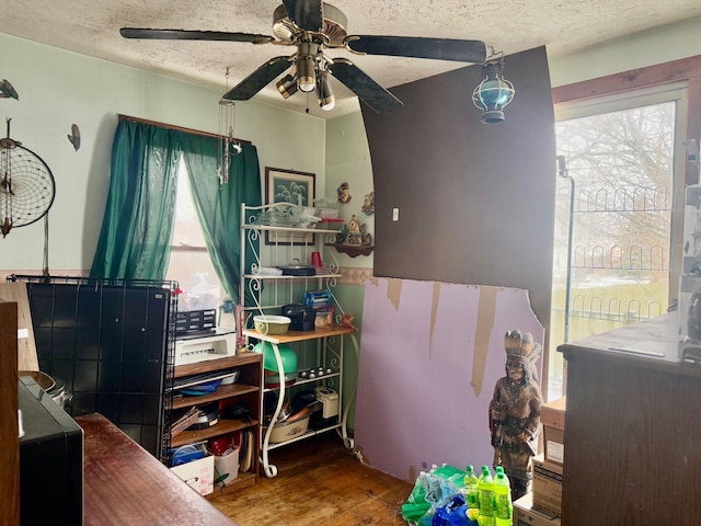 bedroom with a textured ceiling, ceiling fan, and wood-type flooring