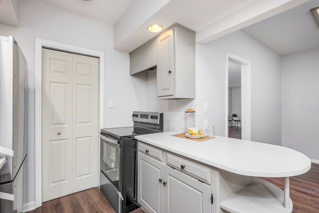 kitchen featuring white cabinetry, dark hardwood / wood-style floors, kitchen peninsula, stainless steel electric range oven, and a breakfast bar area