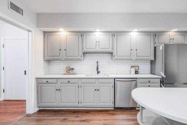 kitchen with stainless steel appliances, backsplash, dark hardwood / wood-style flooring, and sink