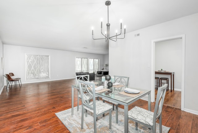 dining space featuring dark hardwood / wood-style flooring and a chandelier