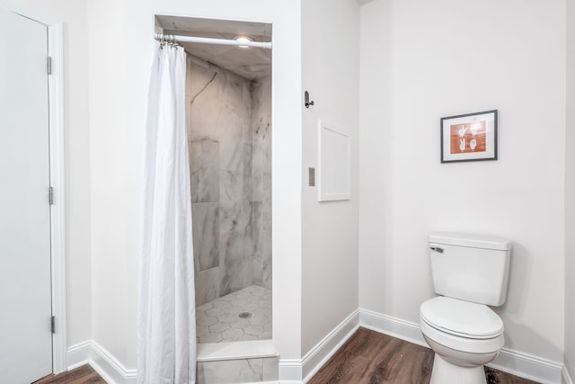 bathroom with wood-type flooring, toilet, and a shower with curtain