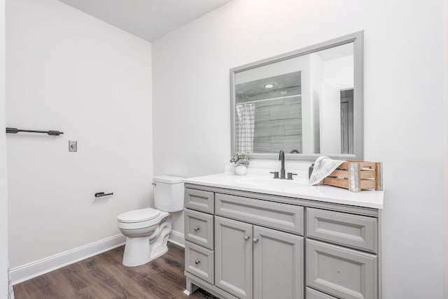 bathroom featuring toilet, walk in shower, wood-type flooring, and vanity