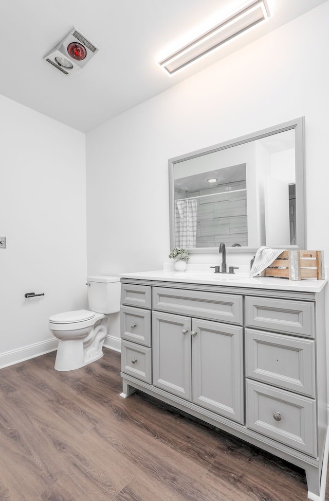 bathroom featuring toilet, a shower with curtain, hardwood / wood-style floors, and vanity