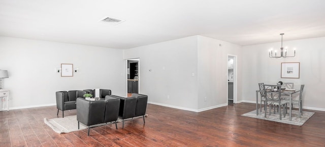 living room with dark wood-type flooring and an inviting chandelier