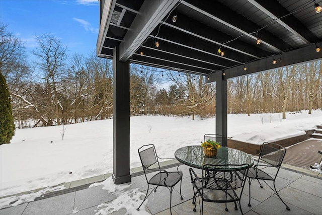 snow covered patio featuring outdoor dining area