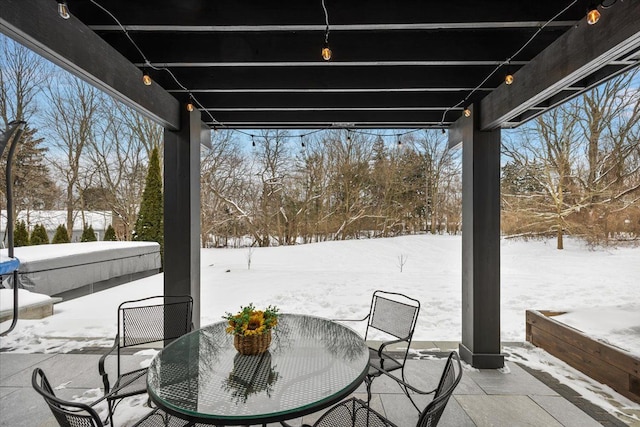 snow covered patio featuring outdoor dining area