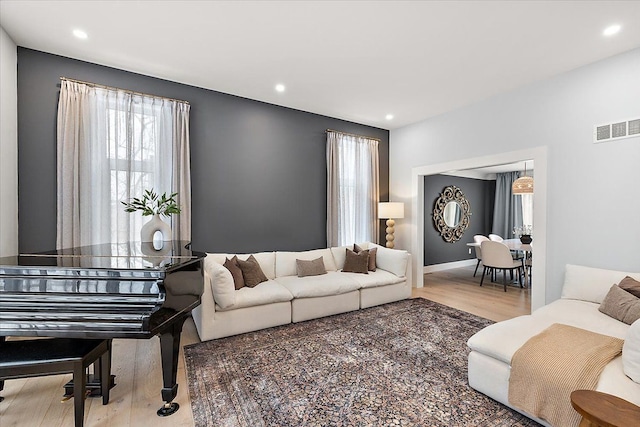 living area featuring recessed lighting, visible vents, and wood finished floors