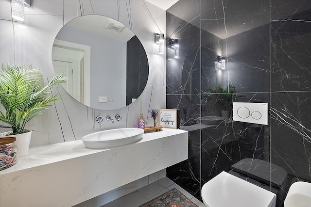 bathroom with toilet, visible vents, tile walls, and vanity