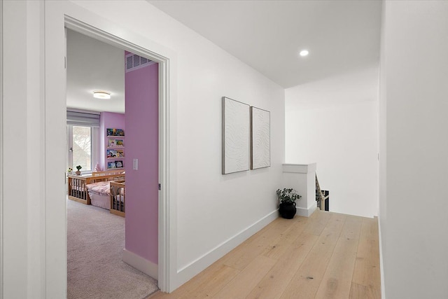 hall featuring an upstairs landing, recessed lighting, visible vents, and baseboards