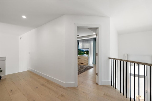 corridor with recessed lighting, an upstairs landing, light wood-style flooring, and baseboards