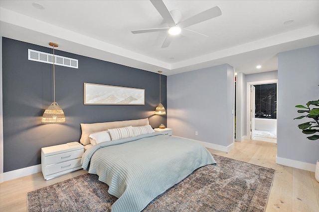 bedroom with light wood-style floors, baseboards, visible vents, and a ceiling fan