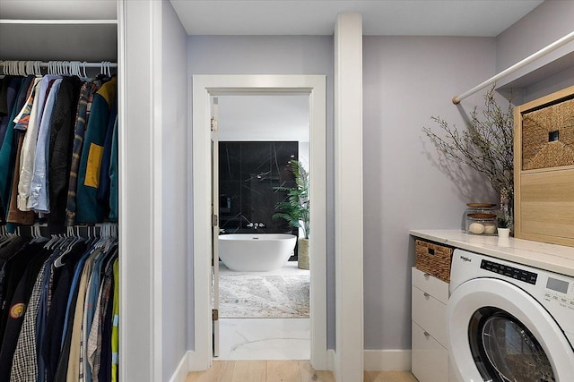 laundry room featuring laundry area, washer / dryer, and baseboards