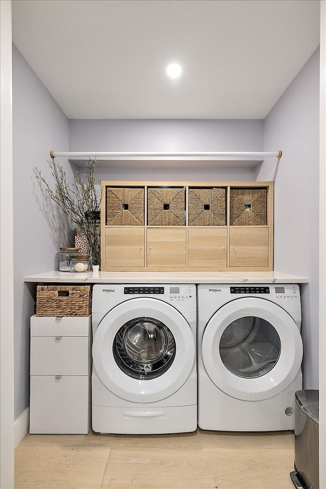 laundry area featuring laundry area, separate washer and dryer, and light wood-style floors