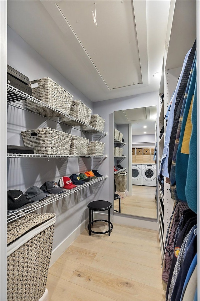 interior space featuring light wood-style floors, attic access, and independent washer and dryer