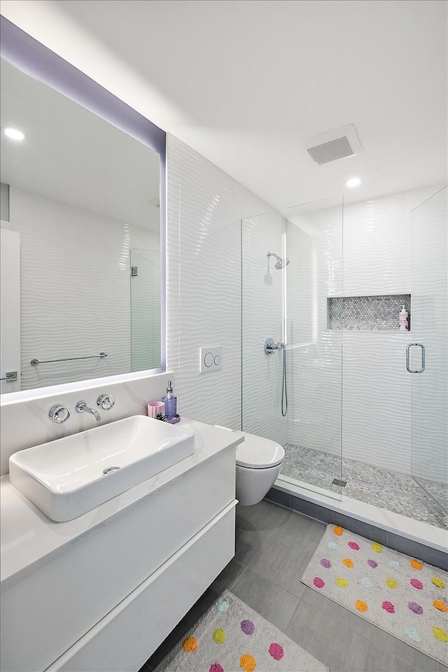 full bathroom with visible vents, toilet, a shower stall, and vanity