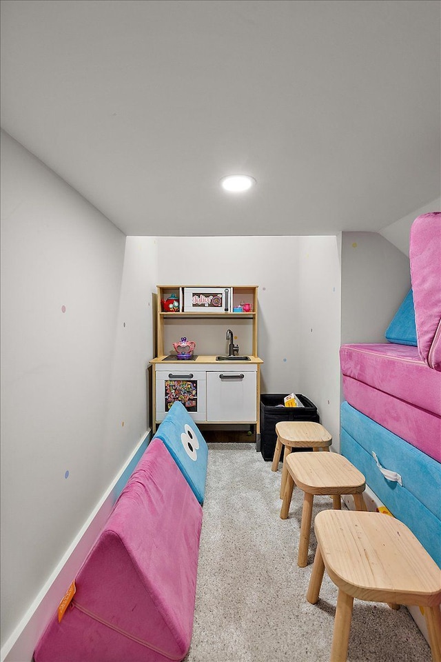 recreation room featuring baseboards, vaulted ceiling, a sink, and recessed lighting