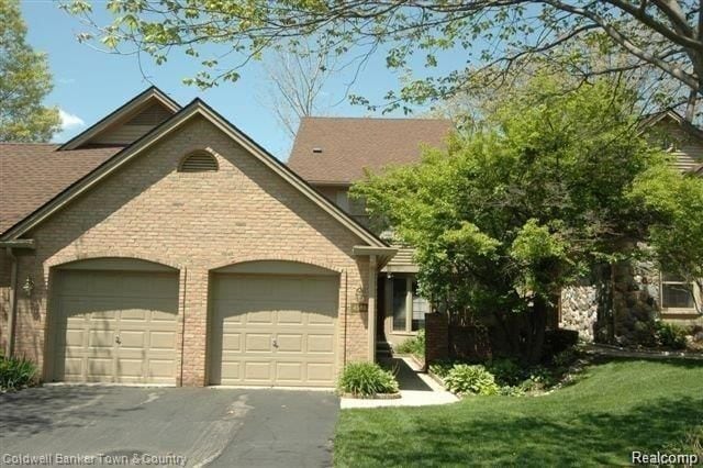 view of front of house featuring a garage and a front lawn