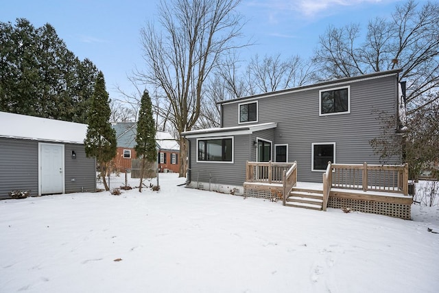 snow covered house featuring a deck