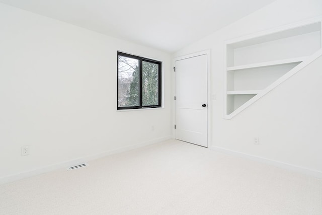 empty room featuring carpet floors and lofted ceiling