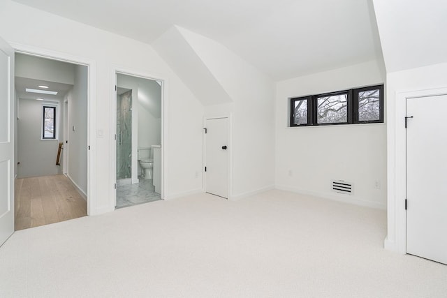 bonus room with plenty of natural light, light carpet, and vaulted ceiling