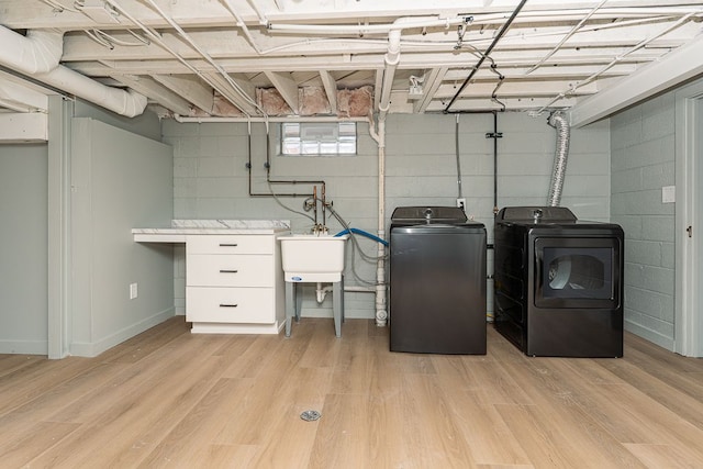 clothes washing area with light hardwood / wood-style floors and washer and clothes dryer