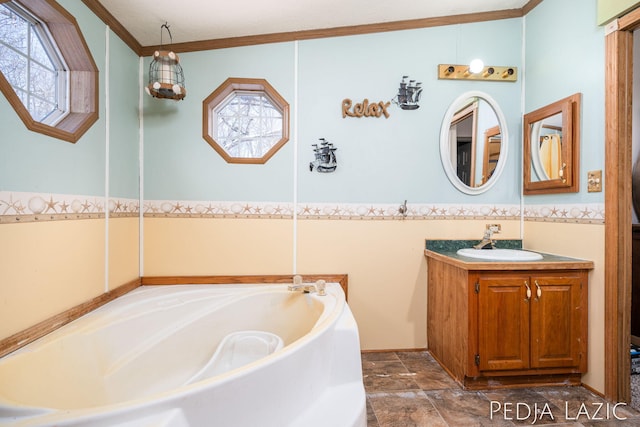 bathroom with a bathing tub, crown molding, vanity, and a healthy amount of sunlight