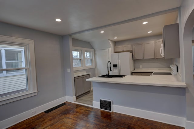 kitchen with kitchen peninsula, sink, white appliances, and gray cabinets