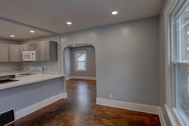 kitchen featuring white appliances, dark hardwood / wood-style floors, and gray cabinets