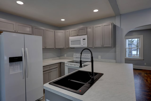 kitchen with white appliances, dark hardwood / wood-style floors, and gray cabinets