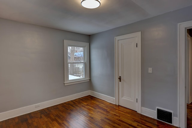 spare room with dark wood-type flooring